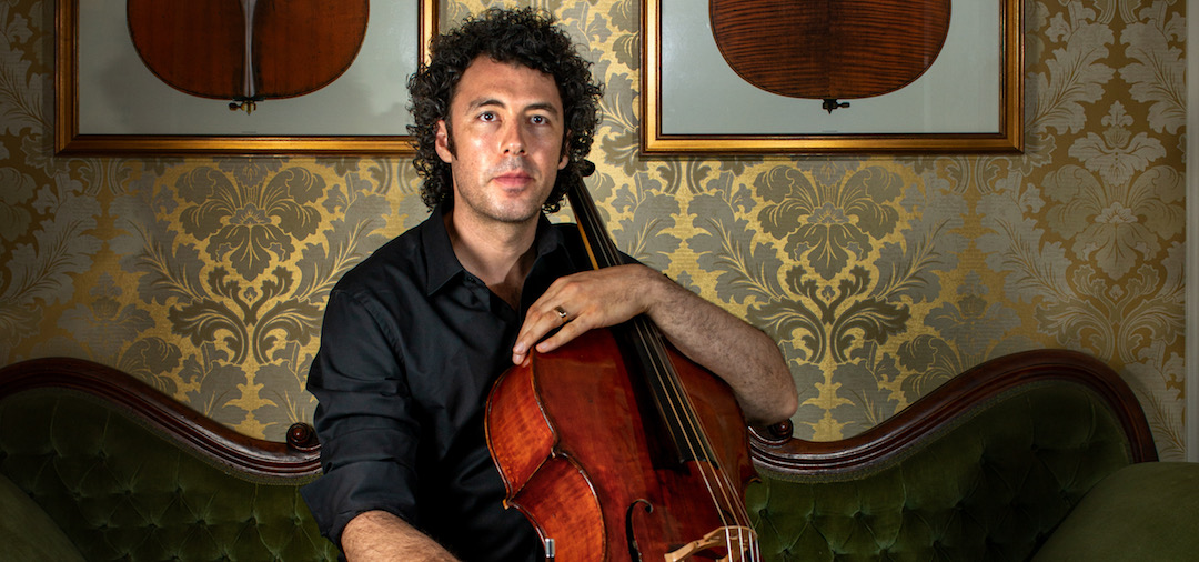 Andre sitting down with his 100-year-old cello, Matilda