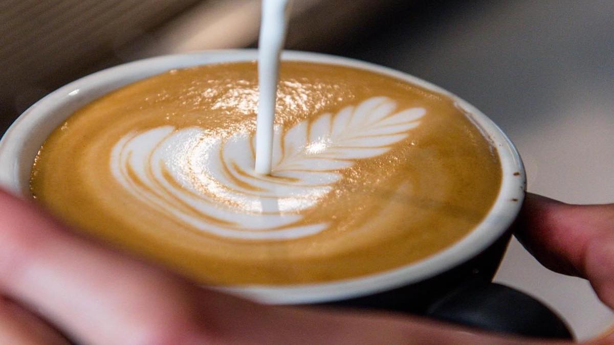 A flat white being made with latte art